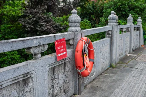 石栏杆上挂着的救生圈与警示牌