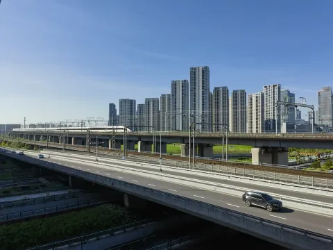 疾驰而来即将过江的高铁列车