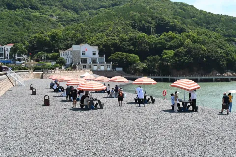 遮阳棚下坐着休息的游客