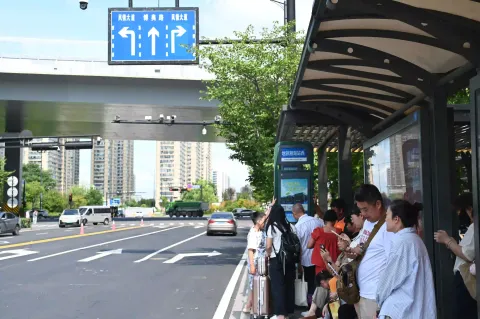路边公交站台等候公交车的乘客